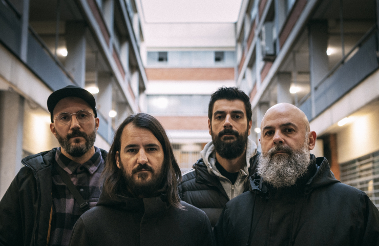 cuatro componentes del grupo, rostro serio