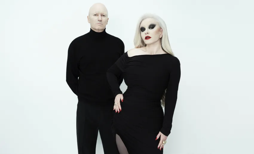 hombre y mujer vestidos de  negro, fondo neutro blanco