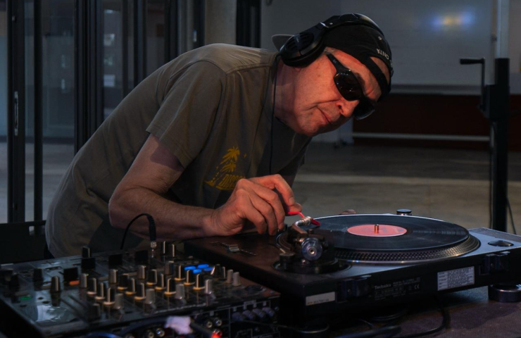 Un hombre poniendo un disco en un tocadiscos