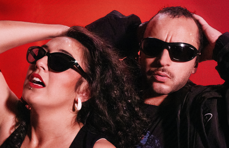 hombre y mujer con gafas de sol fondo rojo