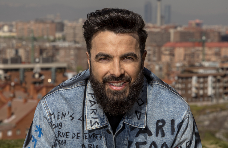 Primer plano de hombre moreno con barba mirando a cámara