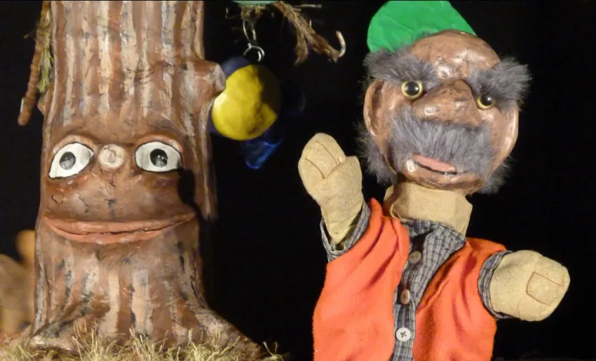 dos marionetas una con forma de tronco de árbol, la otra simula una persona mayor con grandes cejas y bigote gris